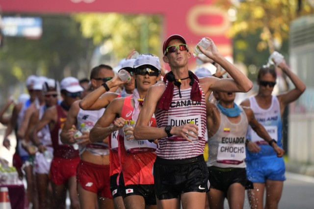 Evan Dunfee pours water over himself during the 50km race walk