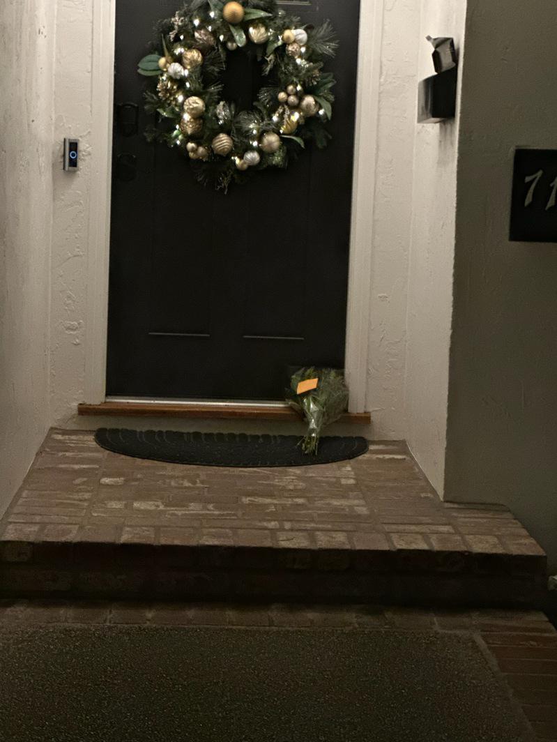 21日周日晚間，灣區正下著豪大雨，不具名的民眾前來獻上一束花在案發屋門口，而那盞...