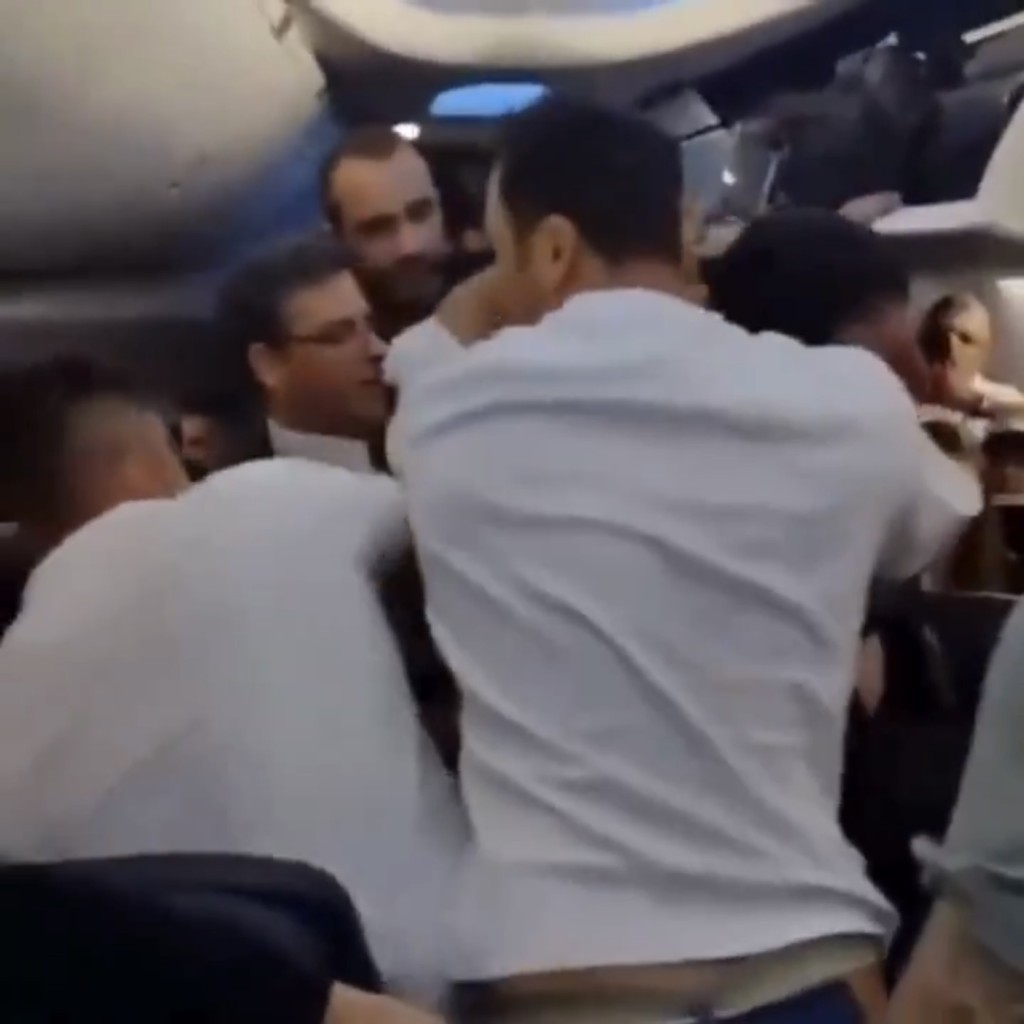 几名乘客合力围住闹事男子。 X 几名乘客合力围住闹事男子。 X