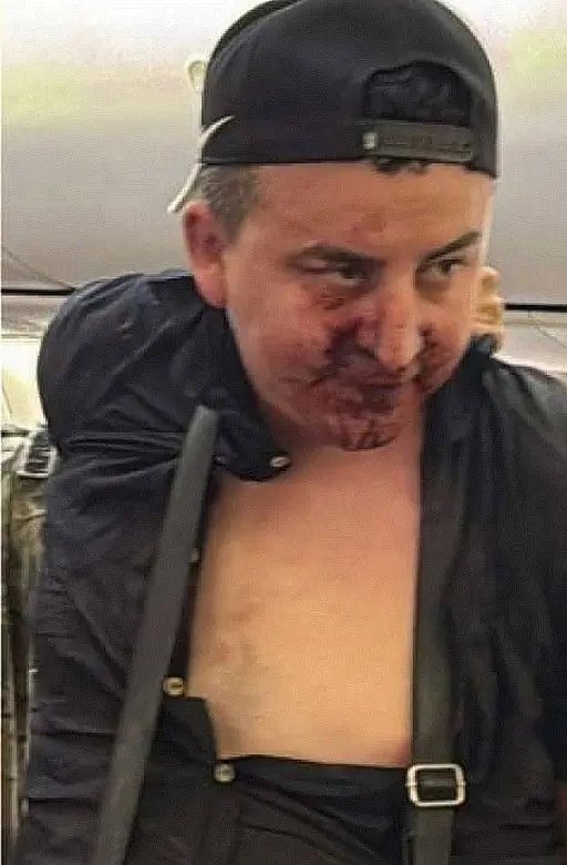 飞机降落后,闹事男子被国家安全小组人员带走。 X 飞机降落后,闹事男子被国家安全小组人员带走。 X