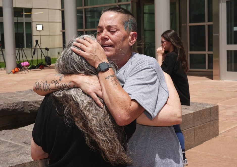 水晶娜·佩奇(右)拥抱贝丝·莫斯利,她们都曾请了一位科罗拉多殡仪馆老板的服务,该老板藏匿了近190具尸体。在这位老板因联邦欺诈罪被判处20年监禁后,时间为2025年6月27日,地点在丹佛。(美联社照片/大卫·扎卢博斯基)