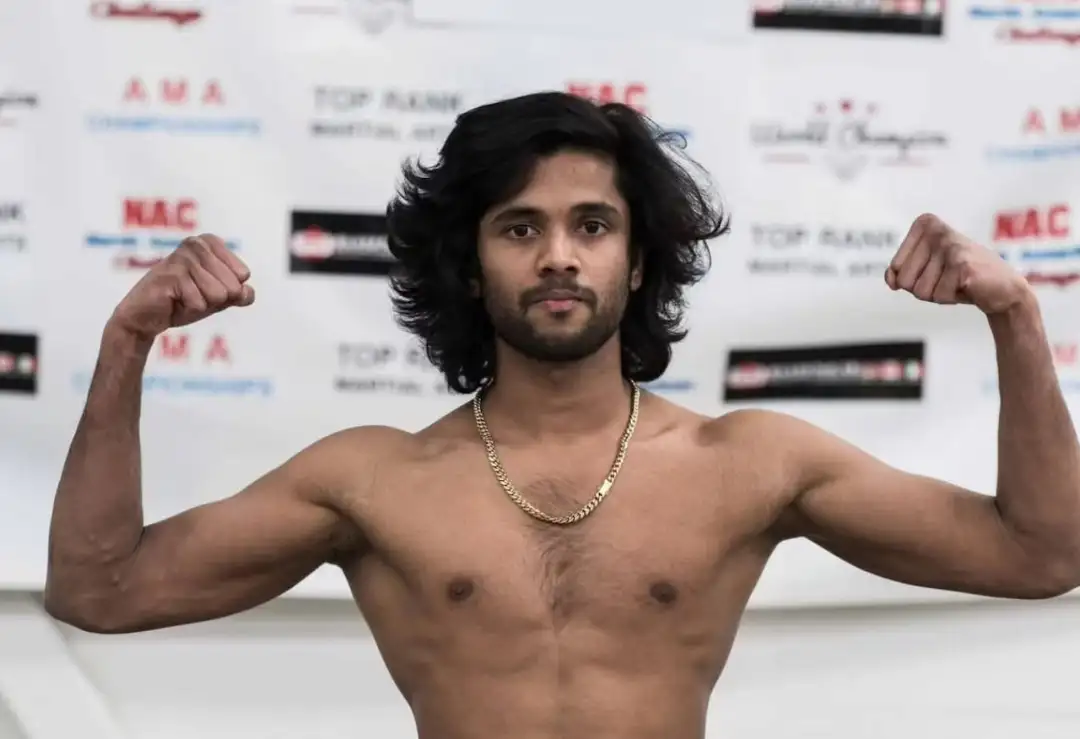 A man stands shirtless and flexes his muscles.
